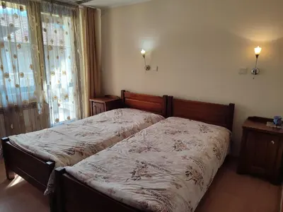 a bedroom with a bed and a window at Къща за гости M-Stone in Bansko