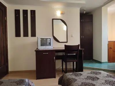 a bedroom with a desk with a tv and a mirror at Къща за гости M-Stone in Bansko