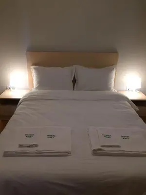 a white bed with two white towels on it at Комплекс Кали, к.к. Цигов Чарк in Tsigov Chark
