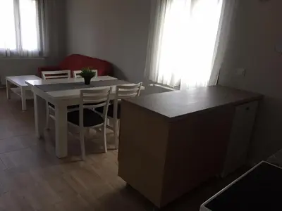 a dining room with a table and chairs and a kitchen at Комплекс Кали, к.к. Цигов Чарк in Tsigov Chark
