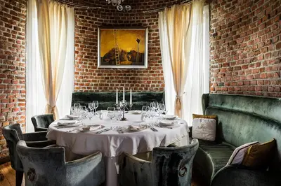 a dining room with a white table and chairs at Chateau Copsa Complex in Moskovets
