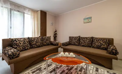 a living room with two couches and a glass table at Alex apartment in Velingrad