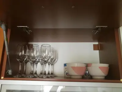a row of wine glasses and bowls on a shelf at G-Apartment, New Inn, 2-rooms in Bansko