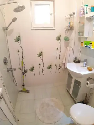 a bathroom with a shower with flowers on the wall at Малко oазисче in Sofia