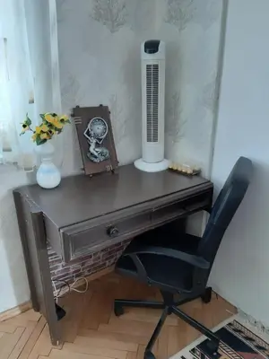 a desk with a fan and a chair in a room at Малко oазисче in Sofia