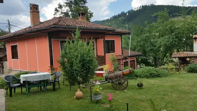 a house with a table and chairs in a yard at Mechta Guest House in Koprivshtitsa