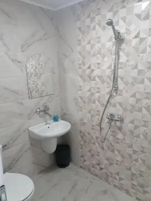 a white bathroom with a shower and a sink at Къща за гости Жани in Zmeitsa