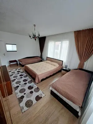 a bedroom with two beds and a rug at Къща за гости Жани in Zmeitsa