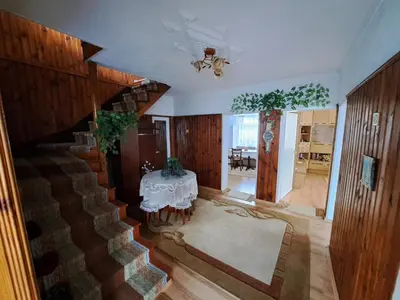 a living room with a table and a staircase at Къща за гости Жани in Zmeitsa