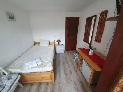 a small bedroom with a bed and a desk at Тодор Прегьов in Bansko