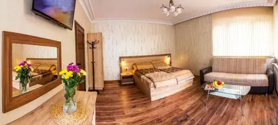 a bedroom with a bed and a couch and a table at Trite Bora Guest House in Narechenski Bani