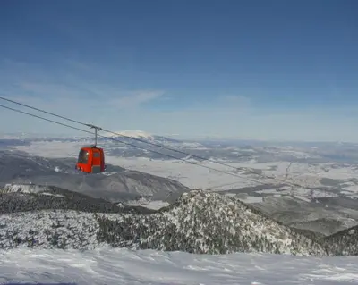 a ski lift flying over a snow covered mountain at Iglika 2, V9 in Borovets