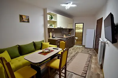 a living room with a green couch and a table at Madini apartment in Velingrad