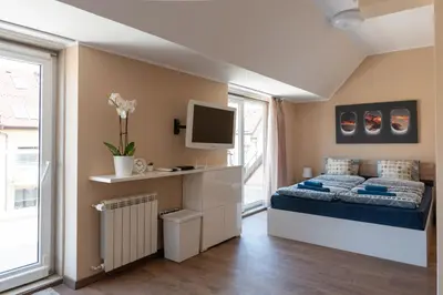 a bedroom with a bed and a tv on the wall at Studio Talisman in Sofia