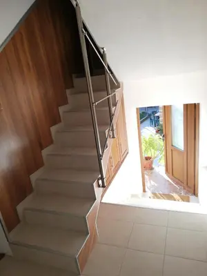 a staircase in a house with a wooden stair case at стаи за гости Диневи in Kalofer