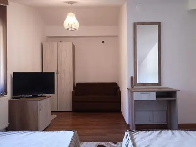 a living room with a television and a couch at стаи за гости Диневи in Kalofer