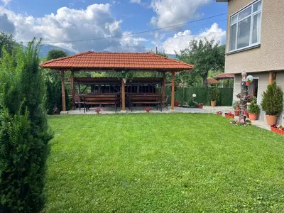 a large gazebo with benches in a yard at Стаи за гости - Къща ТОНЧЕВИ in Kalofer