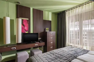 a bedroom with a bed and a desk and a window at Ores Boutique Hotel in Bansko