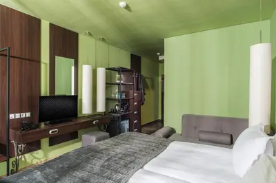 a bedroom with a bed and a desk and a television at Ores Boutique Hotel in Bansko