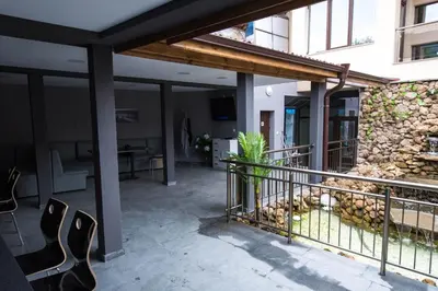 a patio with a fence and a stone wall at Etobicoke -Стаи за гости in Etropole
