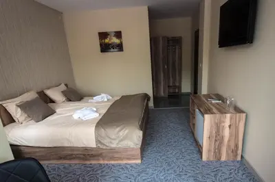 a hotel room with a bed and a television at Etobicoke -Стаи за гости in Etropole