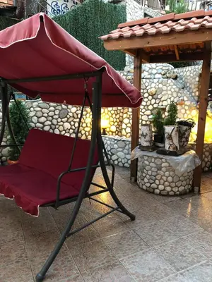 a red chair sitting under a table on a patio at Стаи за Гости Тони и Крис in Devin