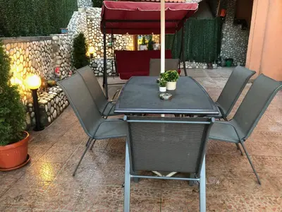 a table and chairs with an umbrella on a patio at Стаи за Гости Тони и Крис in Devin