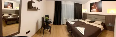 a bedroom with two beds and a chair in it at Стаи за Гости Тони и Крис in Devin