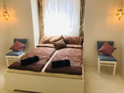 a bedroom with a bed with two chairs and a window at Golden Pearl - jacuzzi top center luxury apartment in Sofia