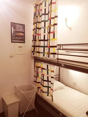 a small room with a bunk bed with a curtain at PIJAMA HOUSE - Bike & Bed in Plovdiv