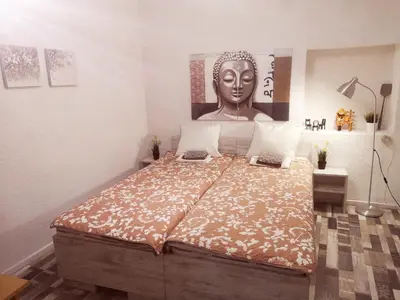 a bedroom with a large bed with a statue on the wall at PIJAMA HOUSE - Bike & Bed in Plovdiv