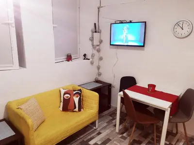 a living room with a yellow couch and a table at PIJAMA HOUSE - Bike & Bed in Plovdiv