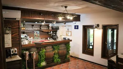 a restaurant with a bar in the middle of a room at Zlaten Rozhen Family Hotel- Monument of Cultural Significance in Rozhen