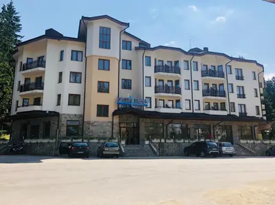 a large building with cars parked in a parking lot at Studio Villa Park Premium in Borovets