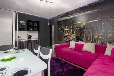 a living room with a pink couch and a table at VITOSHKA Pleasure place in Sofia