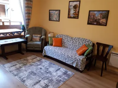 a living room with a couch and a chair at Апартамент Allegri Padrini Комплекс Вели Хилс in Velingrad