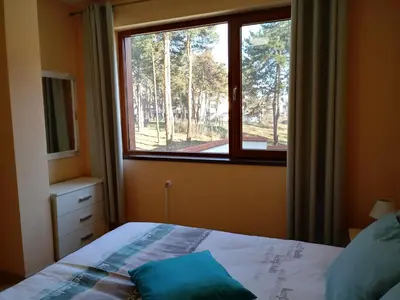 a bedroom with a bed and a window at Апартамент Allegri Padrini Комплекс Вели Хилс in Velingrad