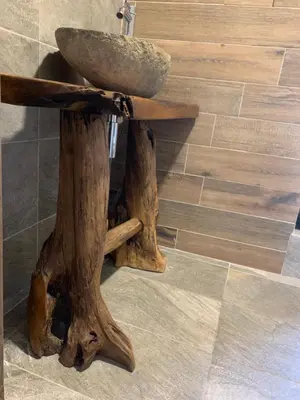 a sink made out of logs with a stone on top at Charming apartment in the heart of Bansko in Bansko