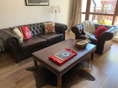 a living room with leather couches and a coffee table at Charming apartment in the heart of Bansko in Bansko