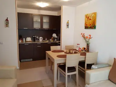 a kitchen and dining room with a table and chairs at Apartments in Borovets Gardens in Borovets