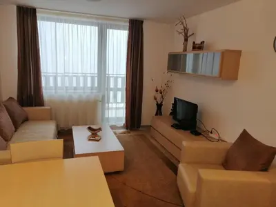 a living room with a couch and a tv at Apartments in Borovets Gardens in Borovets