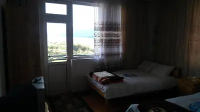 a small bed in a room with a window at Айрови in Sarnitsa