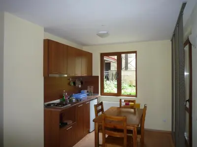 a kitchen with a table and a small table and a window at Ski Apartment in Castle Complex in Pamporovo