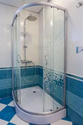 a glass shower in a bathroom with blue tiles at Stunning location and views!Foothills of Old town! in Plovdiv