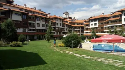 a person standing in a park next to a building at Apartman u kompleksu Royal Towers in Bansko