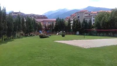 a large grassy field in front of some buildings at Apartman u kompleksu Royal Towers in Bansko