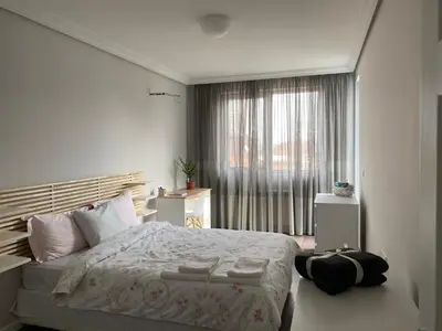 a bedroom with a large bed and a window at Apartment The Orchid in Sofia