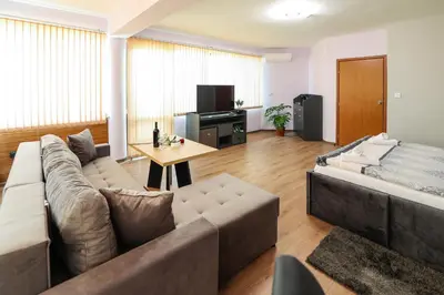 a living room with a couch and a table at Family Hotel Gotse Delchev in Gotse Delchev