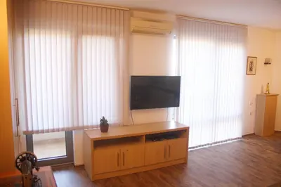 a living room with a flat screen television on a wooden cabinet at Central Square Apartment in Plovdiv