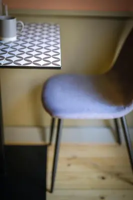 a chair sitting at a table with a cup of coffee at Beautiful best location apartment Red Mouse in Plovdiv